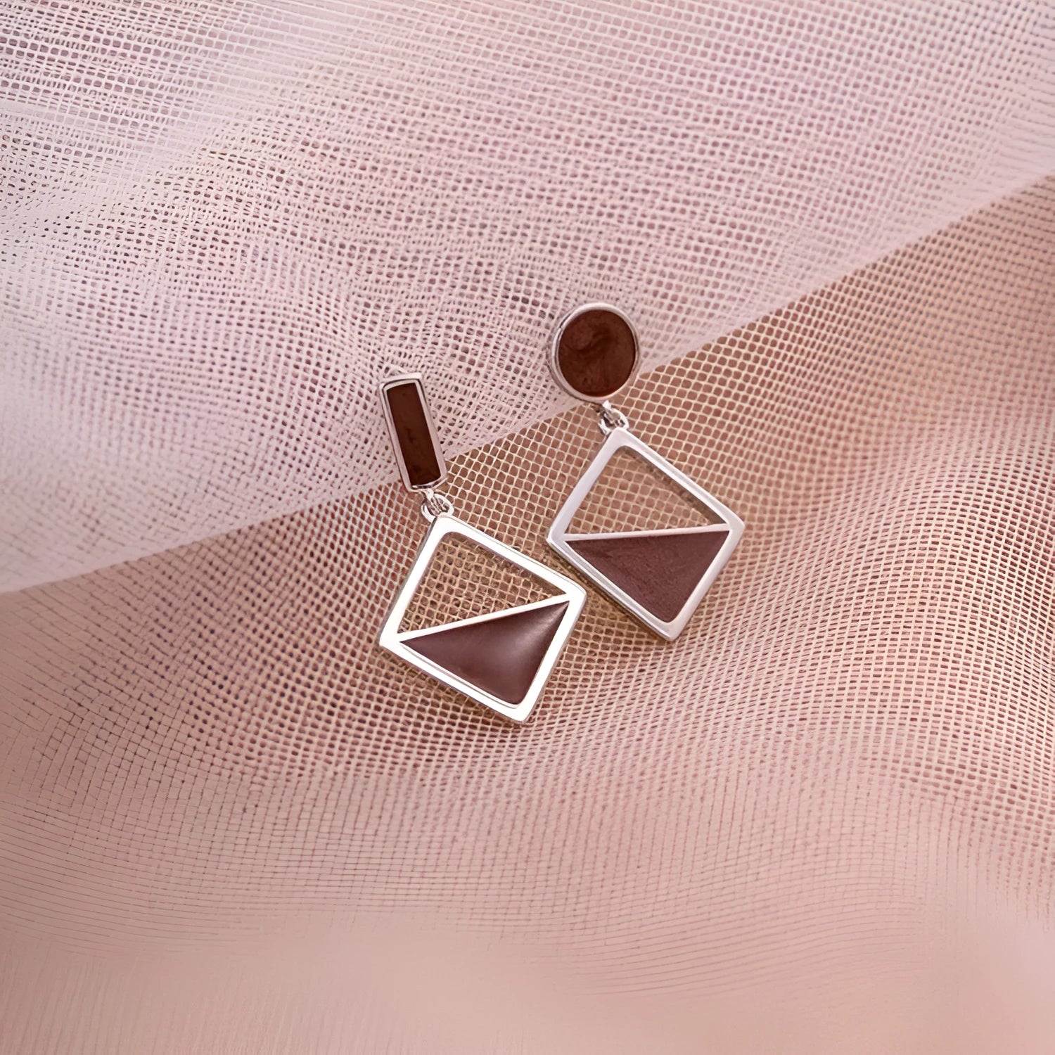 925 silver asymmetrical love earrings with frosty electroplated brown finish on a light background