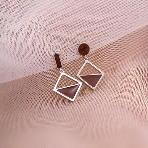 925 silver asymmetrical love earrings with frosty electroplated brown finish on a light background