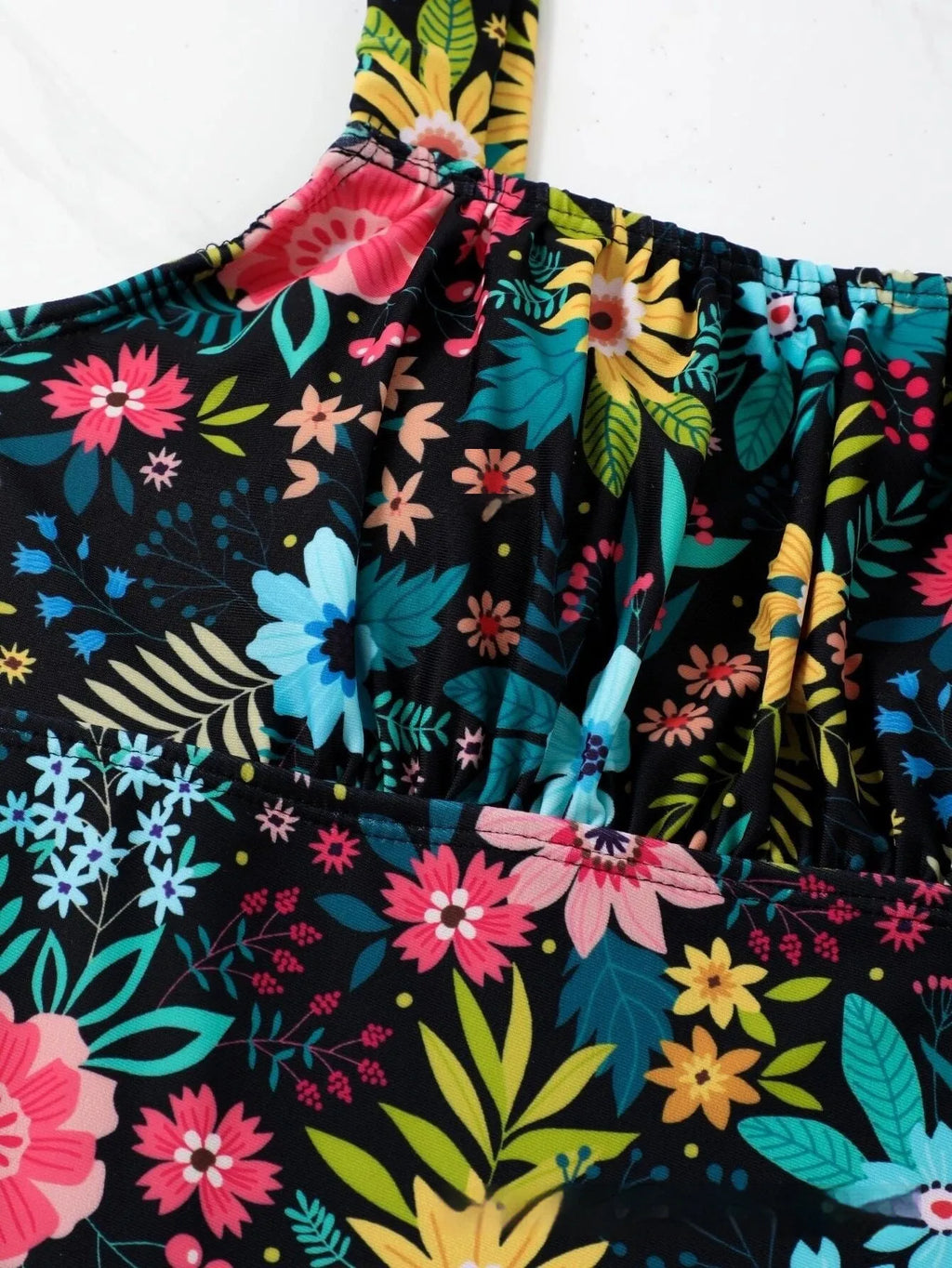 Women's black and floral print one-piece swimsuit with full coverage on a mannequin.