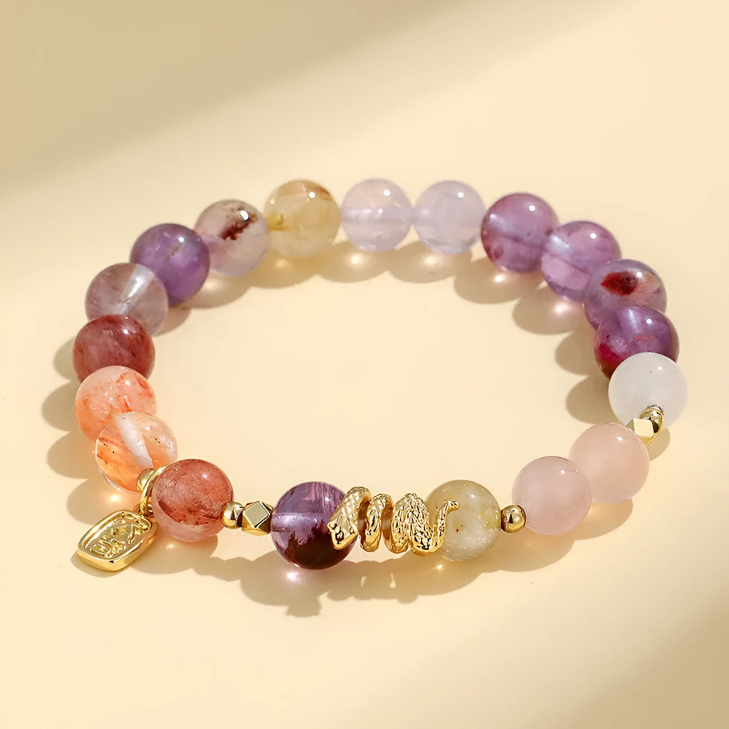 Handcrafted women's crystal bracelet with a lucky snake charm and red sealant flowers on a wrist.