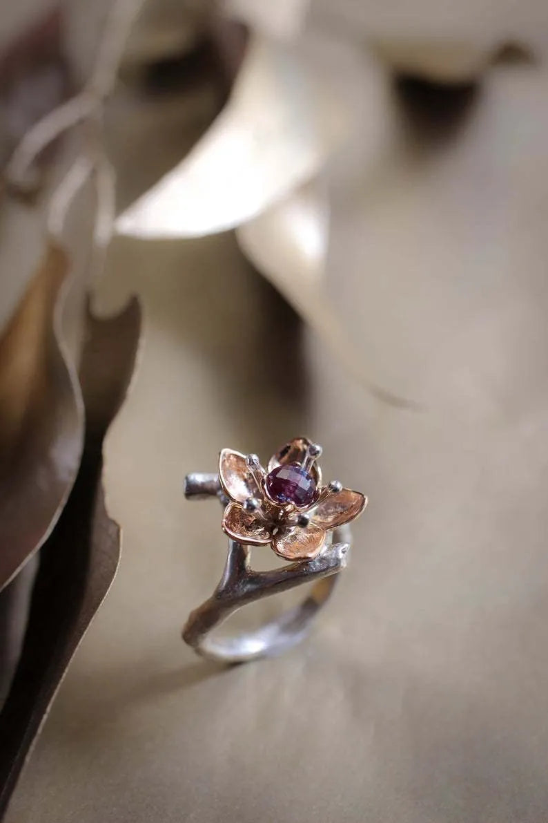 Silver two-tone alloy ring with a geometric floral pattern on a model's hand.