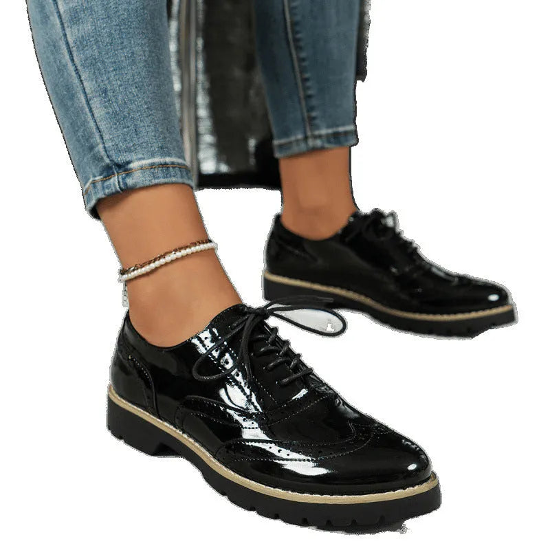 Women's black sequinned loafers with a wedge heel and lace-up fastening.