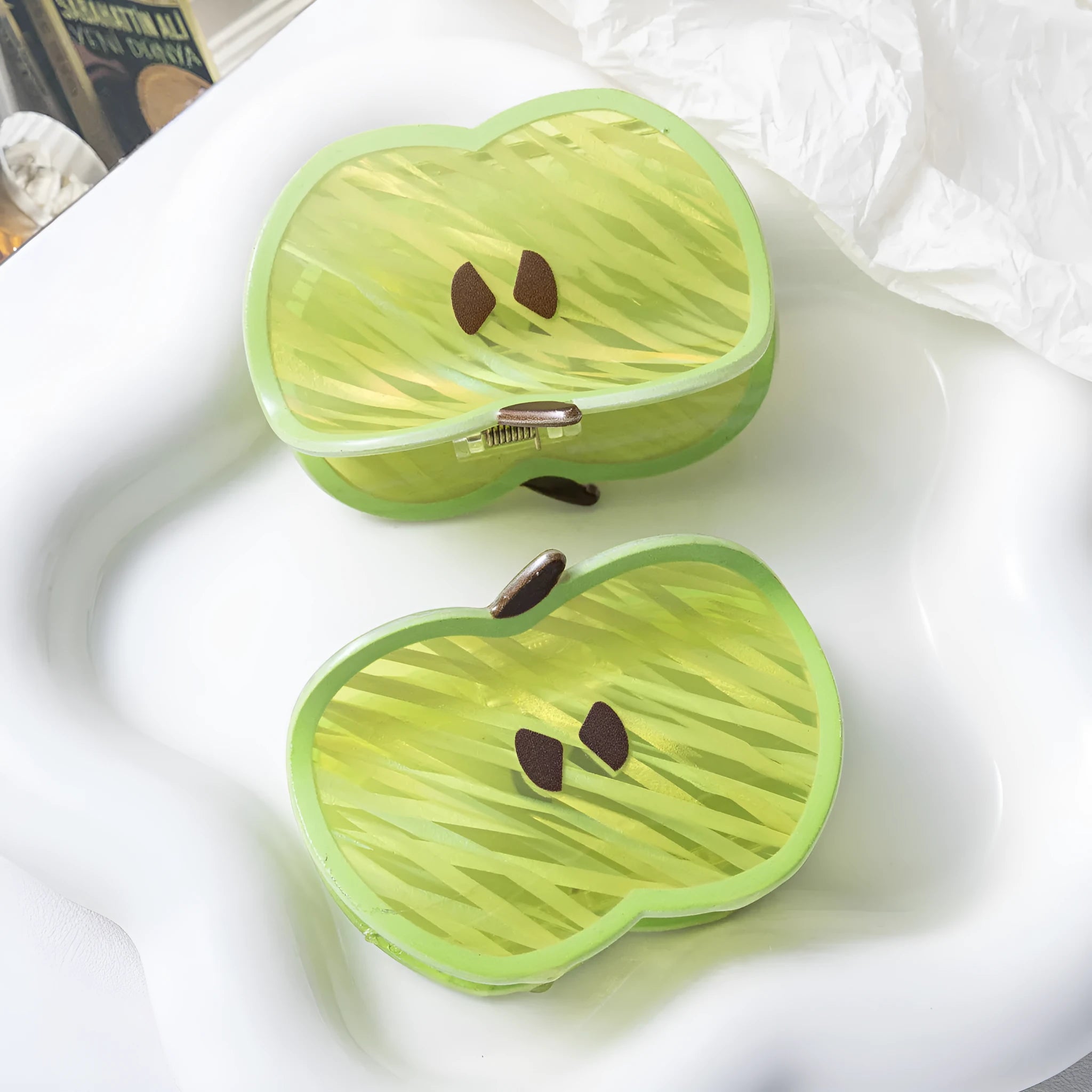 Green apple-shaped claw clip with polished PVC finish, 7.5cm long, on a plain background