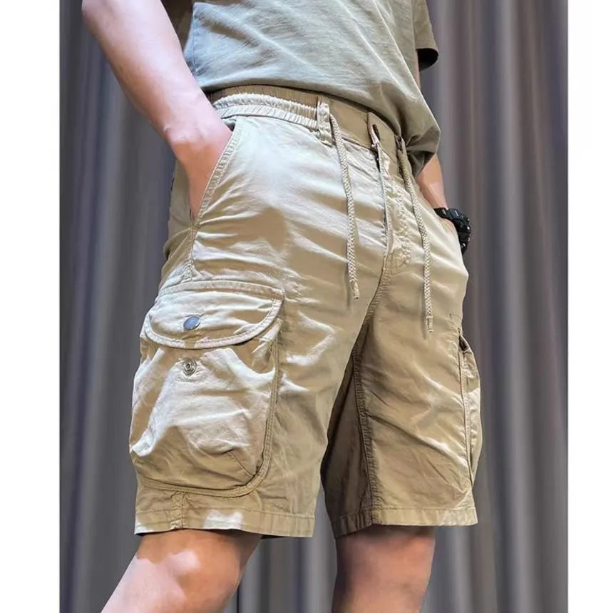 Loose straight-leg khaki overalls trousers with elastic waist and front slash pockets on a neutral background