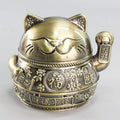 Zinc alloy lucky cat ashtray with cover in gold black colour on a wooden table