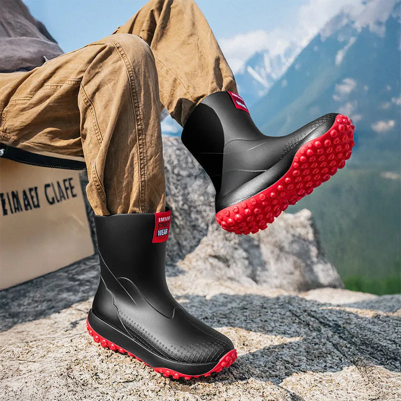 Men's black red PVC rain boot with round toe and plastic sole on a wet surface