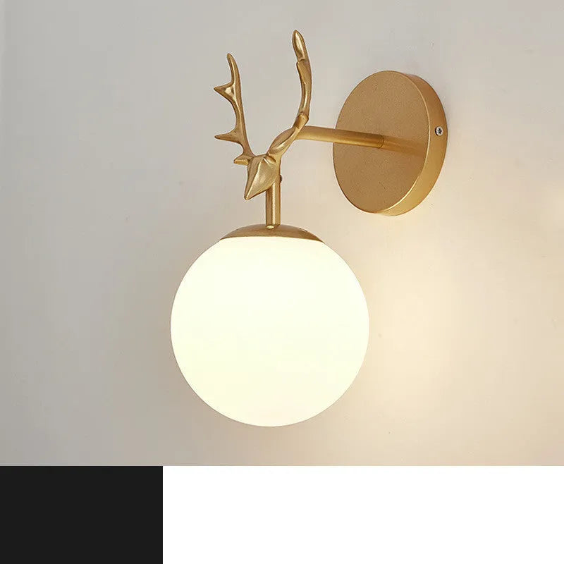 Round hand-blown glass wall lamp with golden water pattern finish mounted on a white wall, demonstrating minimalist design.