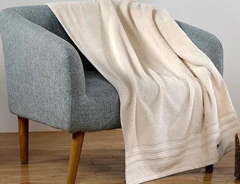 Cotton towel set in brown or beige showing bath sheet, hand towel, and face cloth sizes