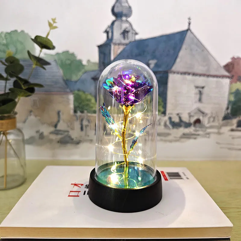 Small decorative night lamp with plastic flowers and a glass-style cover on a black base.
