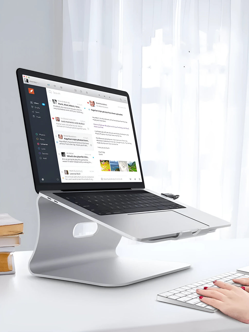 Silver aluminium laptop cooling bracket with striped texture on a wooden desk, rotated at an angle.