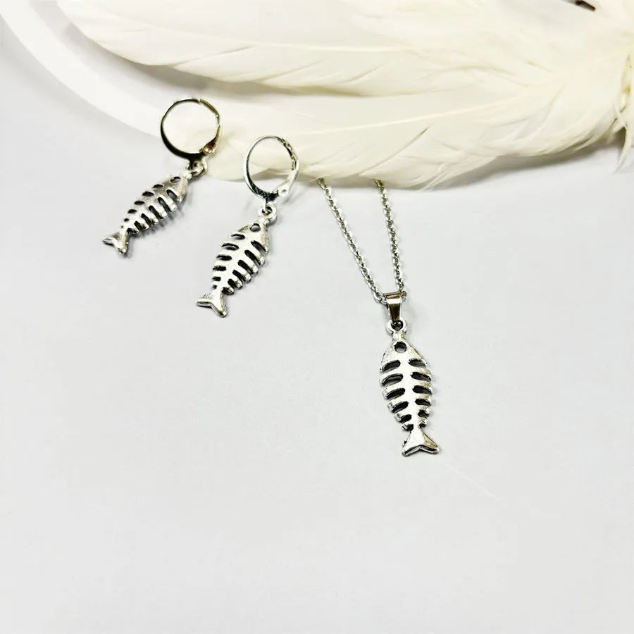 Fishbone pendant necklace and matching earrings set with adjustable chain on retro background