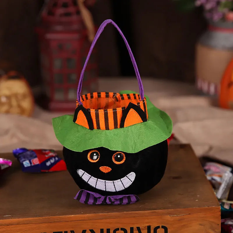 Square black Halloween candy bag with a pumpkin pattern, held by a handle.