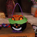 Square black Halloween candy bag with a pumpkin pattern, held by a handle.