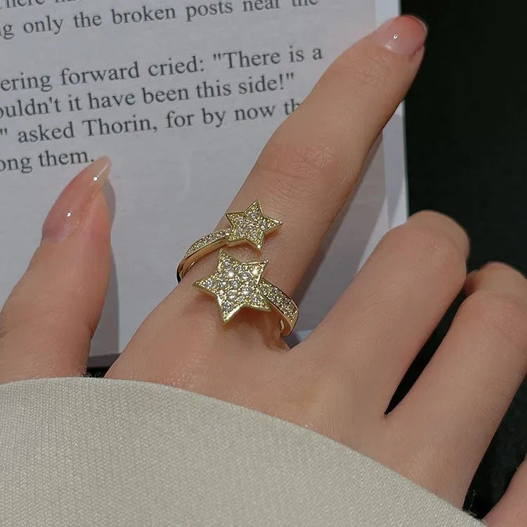Gold cold style zircon star open-end ring and bracelet set on white background
