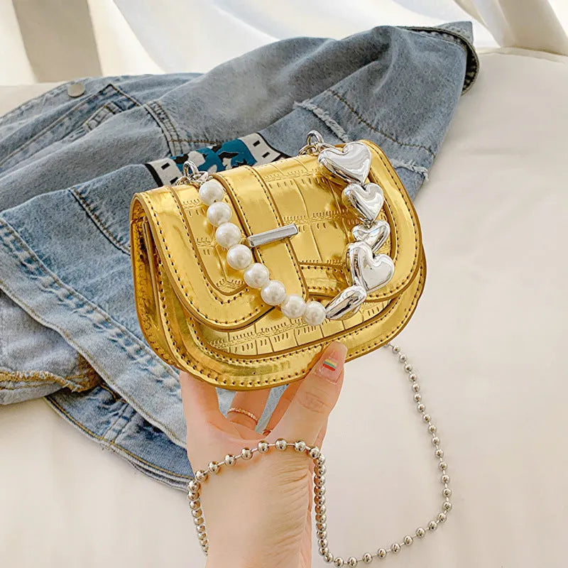 Women's silver mini crossbody bag with a square shape and a single shoulder strap.