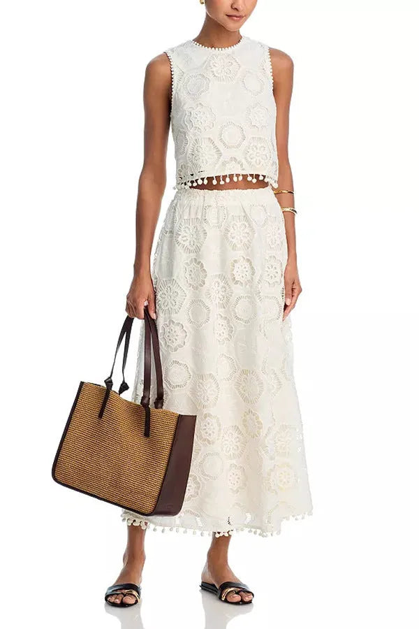 White women's sleeveless top and long skirt set with intricate embroidered retro art design detail.