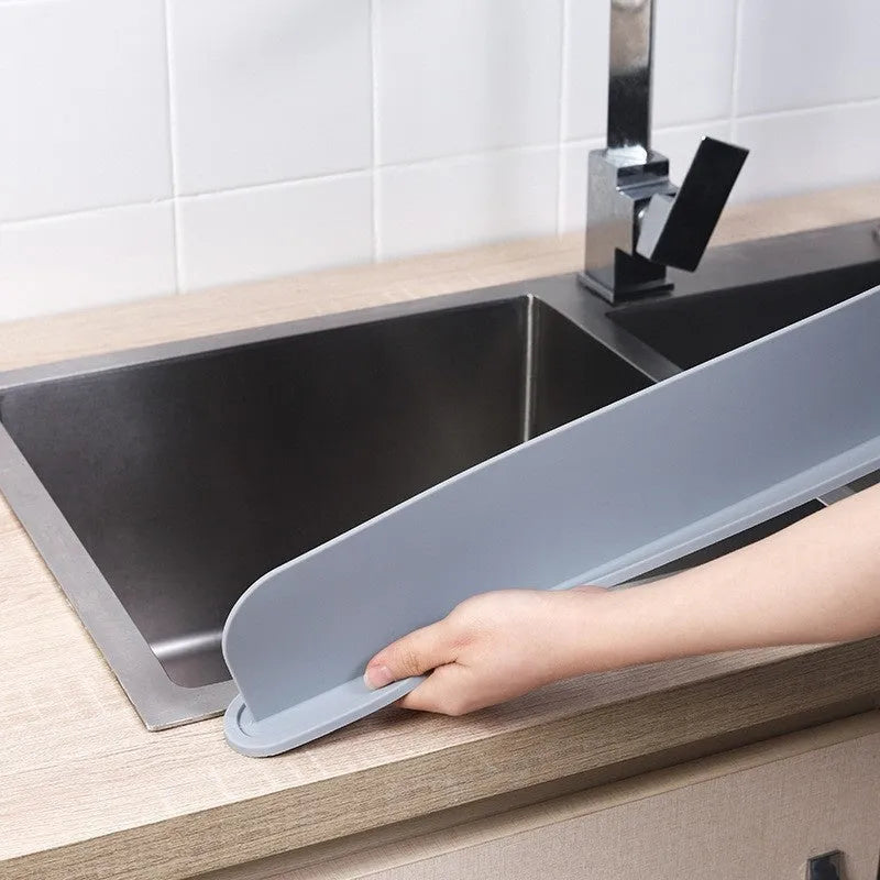Grey silicone kitchen sink splash guard plate measuring 52mm by 85mm