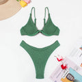 Women's solid green bikini suit with ruffle trim and split leg briefs on a mannequin.