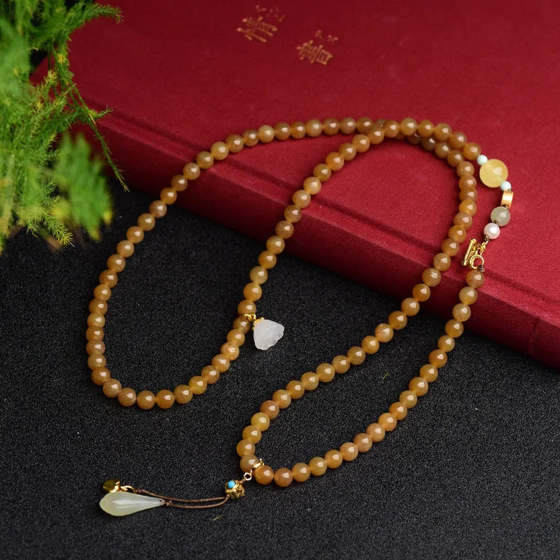 Women's green pine jade and beeswax bracelet with sequin leaves on a 6mm round bead strand.