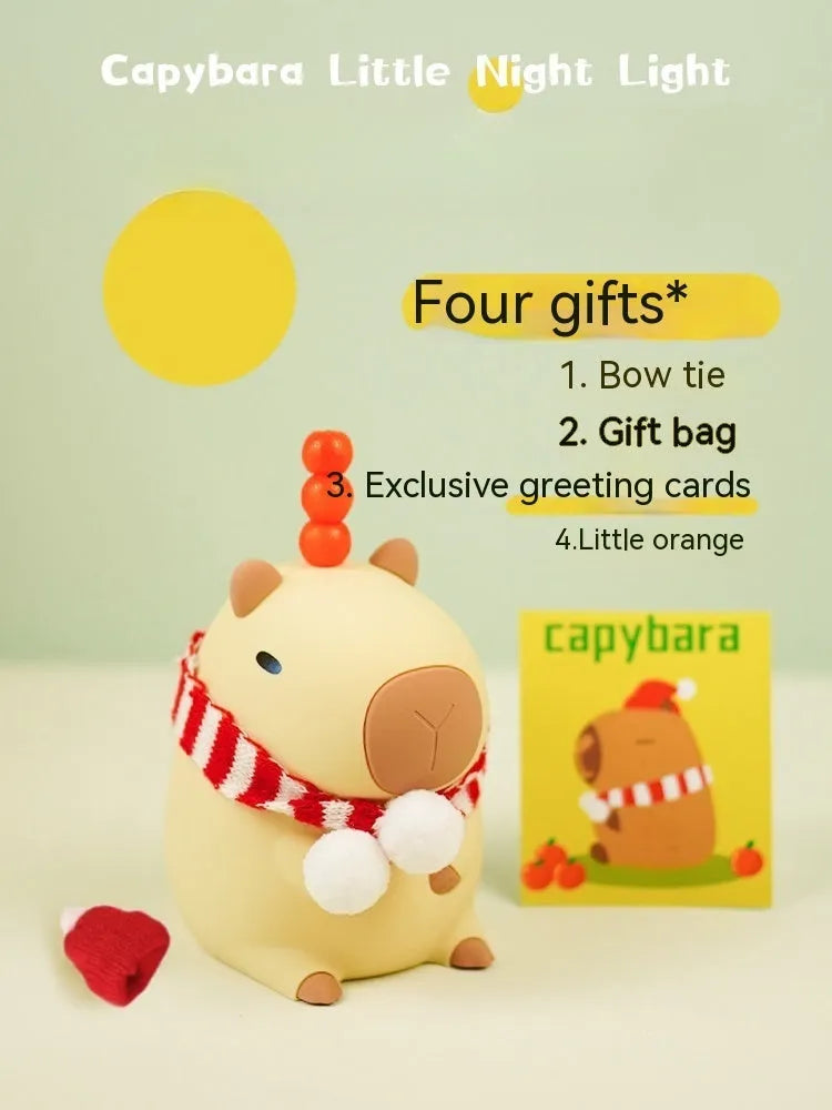 Small capybara-shaped night lamp in silicone and plastic, shown with USB cable.