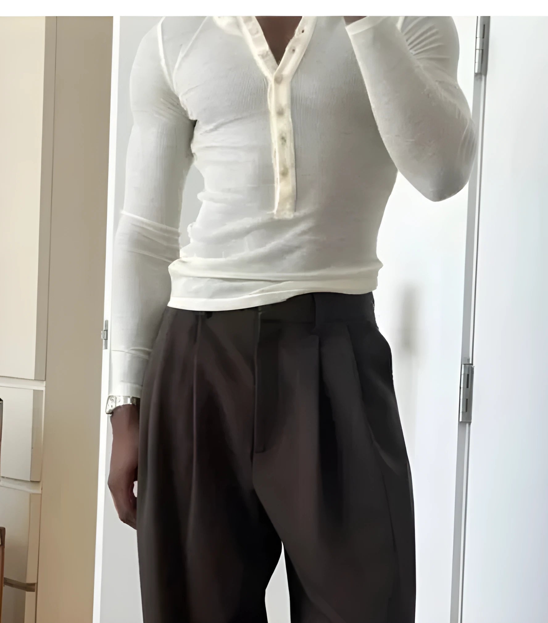 Men's cream-coloured ribbed long-sleeve henley top with button placket on a hanger.