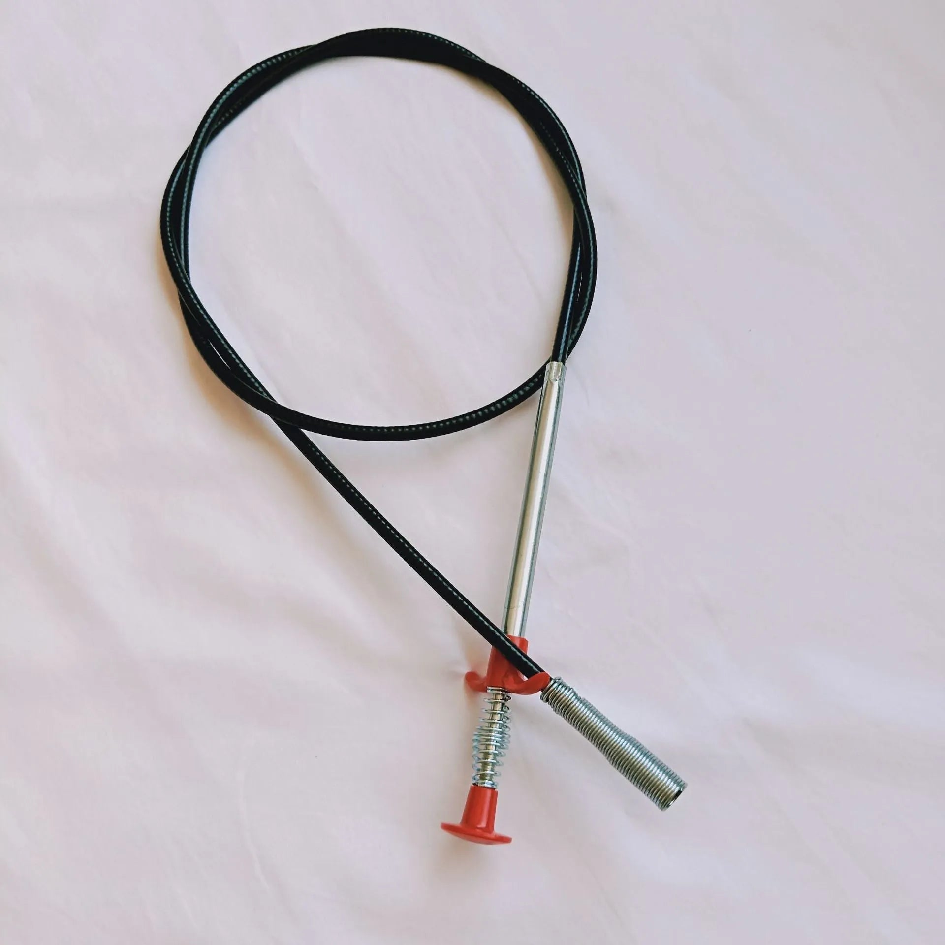 Flexible drain cleaning spring tool with gripped handle for removing hair from pipes