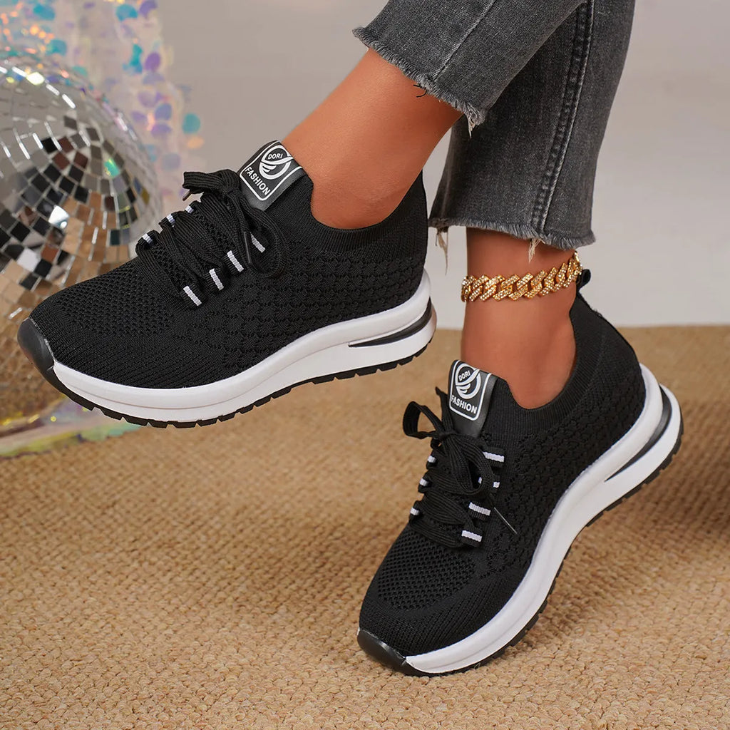 Women's black platform sneakers with mesh upper and lace-up front on flat rubber sole
