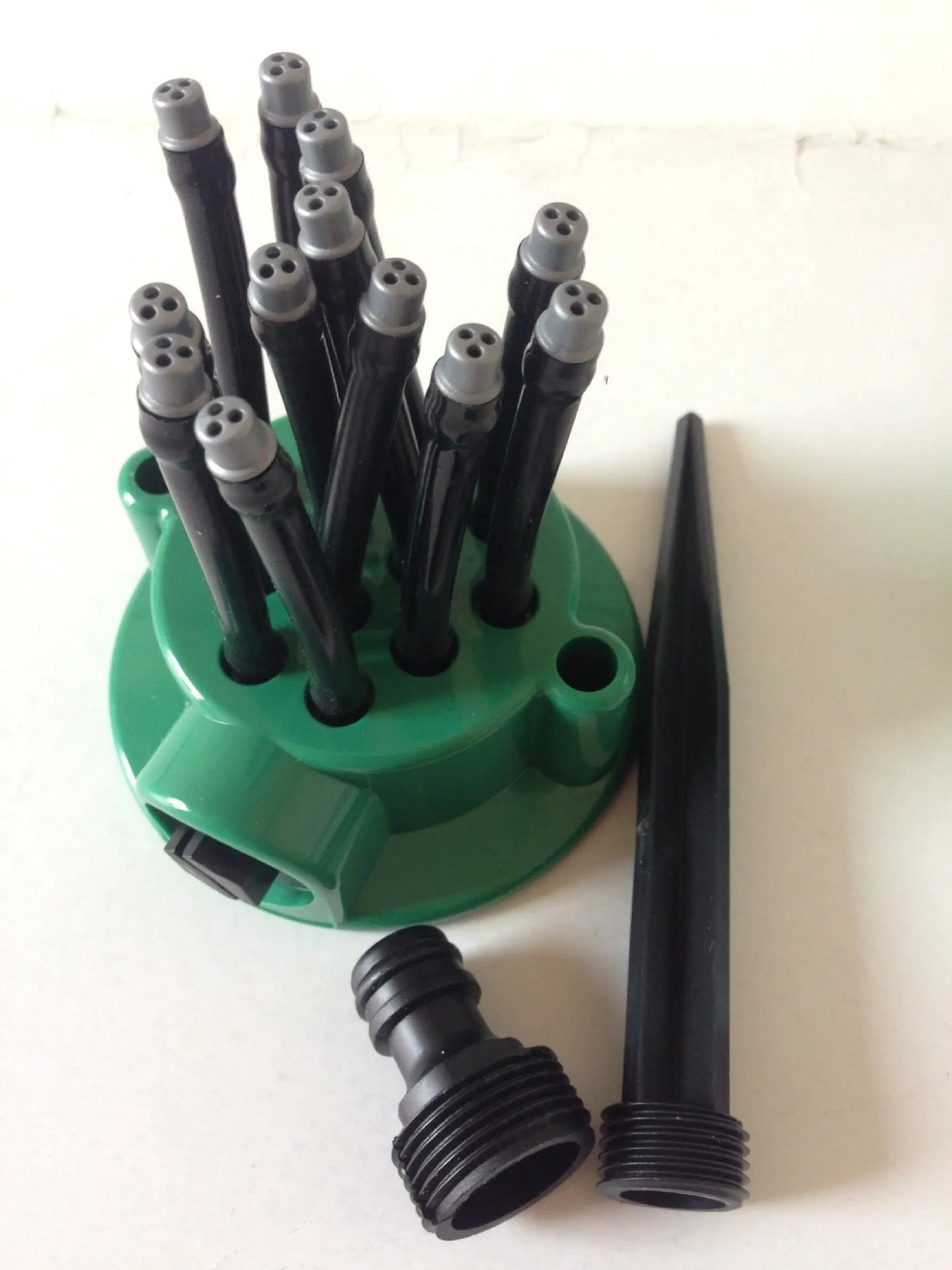 Green adjustable lawn sprinkler with flexible spray noodles and 9cm diameter base