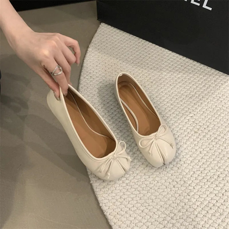 Women's split-toe flat pumps in beige with a round toe and flat rubber sole.
