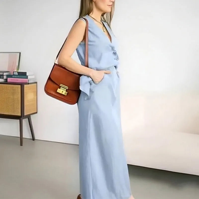 Women's loose blue polyester two-piece suit with sleeveless vest and long skirt on a hanger.