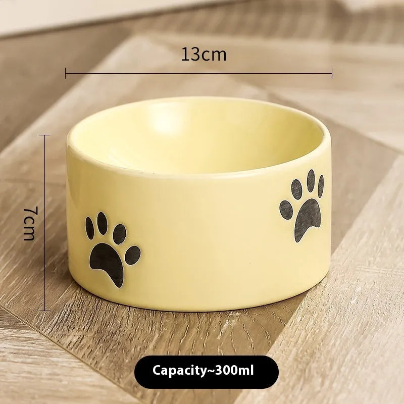 Ceramic cat bowl with cat paw design in black, showing oblique mouth style.