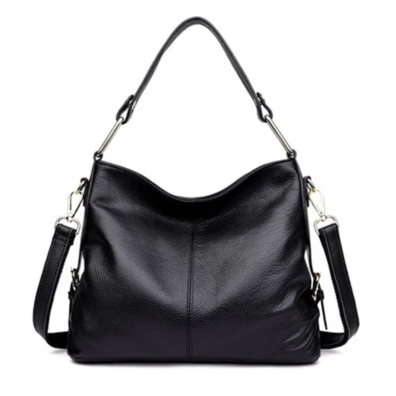Genuine leather vertical square crossbody bag in black with sewing line detail and external pocket.