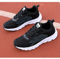 Women's low-top black and white casual running sneakers with MD sole and cross-strap detail.