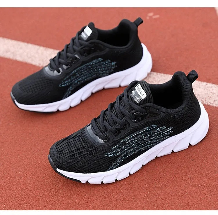 Women's low-top black and white casual running sneakers with MD sole and cross-strap detail.