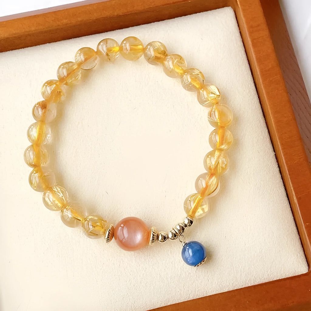 Gold rutilated quartz and sunstone bracelet with round diamond-shaped beads.