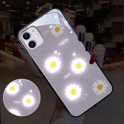 White luminous iPhone case with painted daisies and voice-activated colour-changing LED lights on a smartphone.
