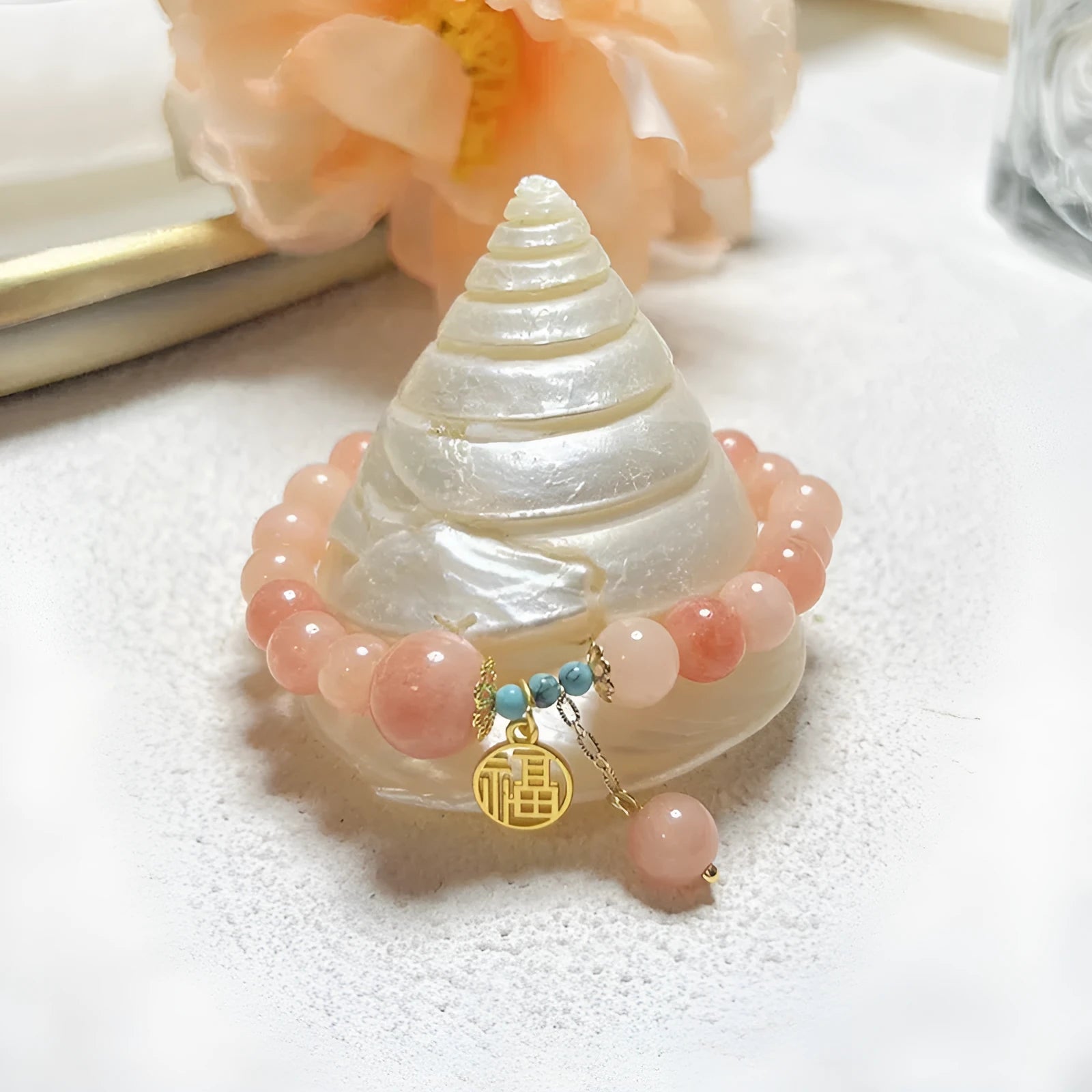 Pink alloy bracelet with natural stone details for women on a simple background.