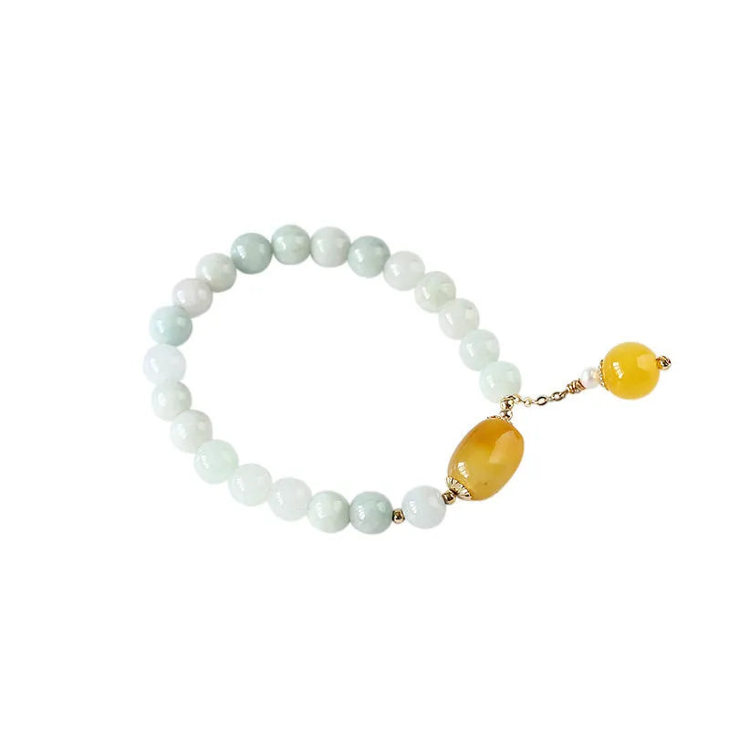 Women's ethnic bracelet with hanging red agate tassel on a gold chain.