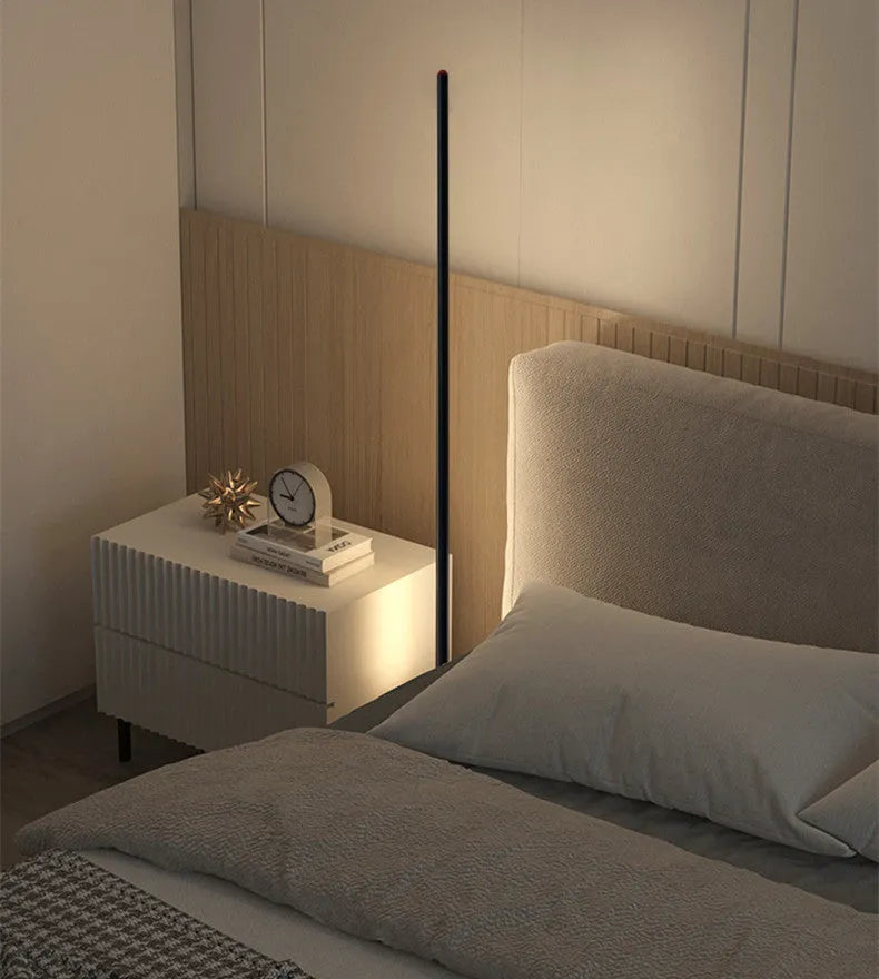 Vertical aluminium alloy floor lamp in modern simplicity style on a table.