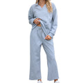 Women's black knitted jacquard suit with lapel sweater and elastic waist cropped pants on a hanger.