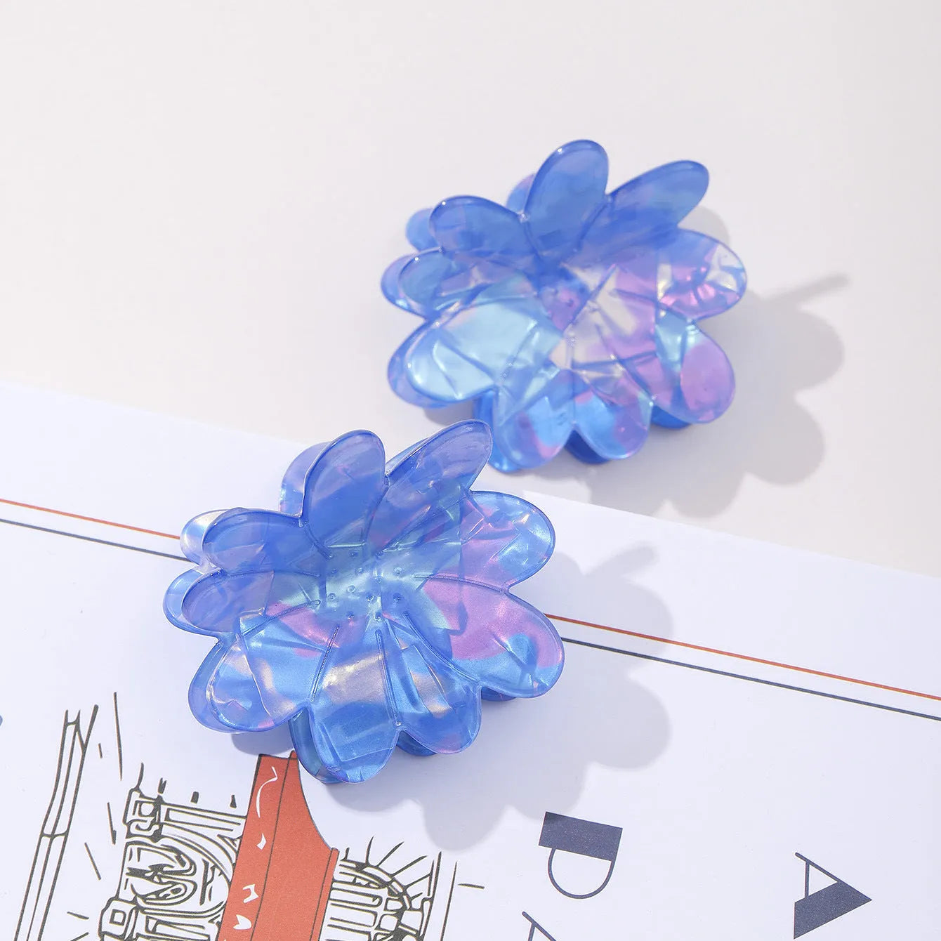 Dazzling blue PVC flower hair clip with glossy finish, 6cm length, on a light background