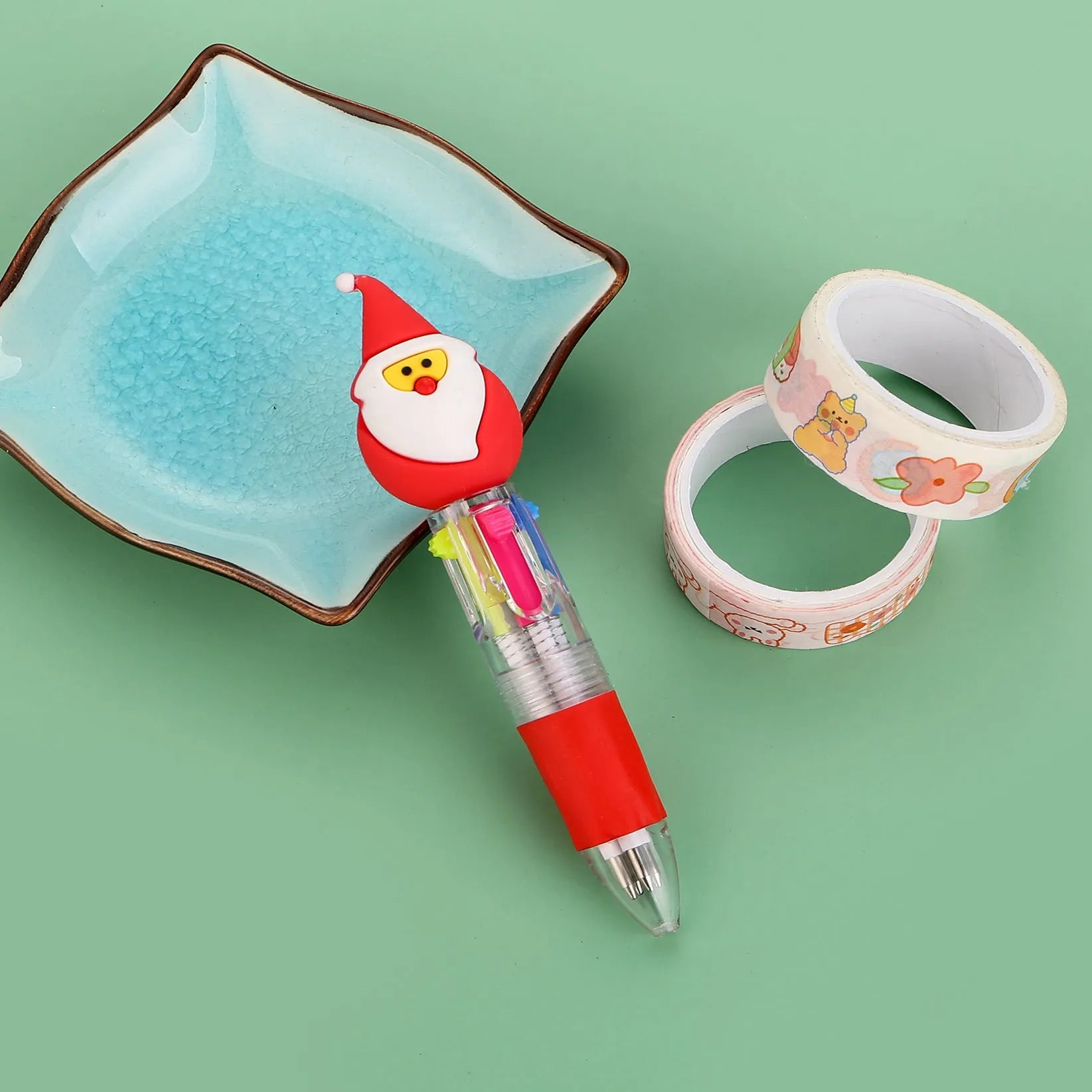 Compact 11cm Christmas ballpoint pen with four colours and festive designs like snowmen and reindeer.