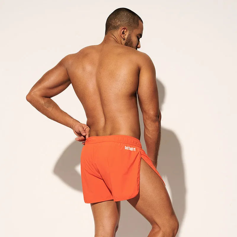 Men's loose beach shorts in orange, fluorescent green and black colours with elastic waistband