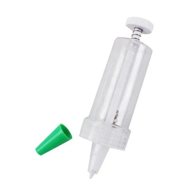 A white plastic mini garden seeder tool, 12cm long, for planting seeds in pots and trays.