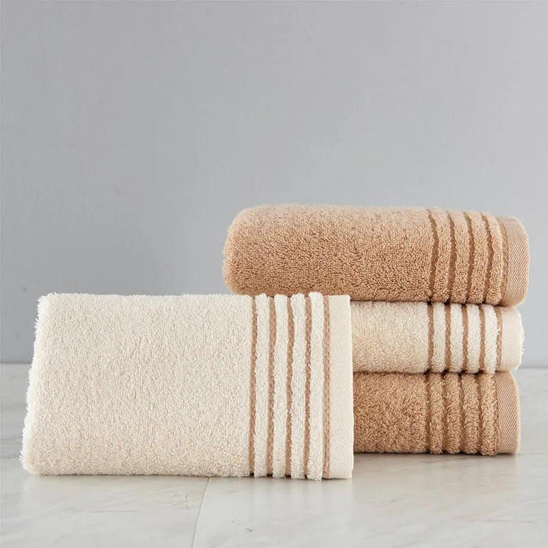 Cotton towel set in brown or beige showing bath sheet, hand towel, and face cloth sizes