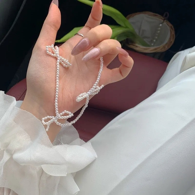 Women's white imitation pearl necklace with sweet bow design and geometric shapes on adjustable chain