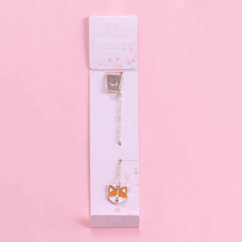 Cartoon-themed alloy metal bookmark charm on a book page.