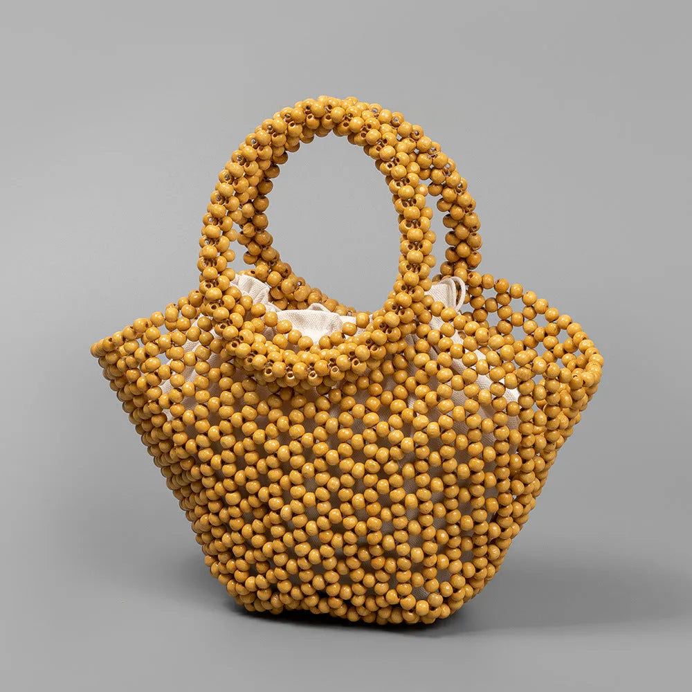 Hand-woven wooden bead beach bag in dumpling shape with strapless design.