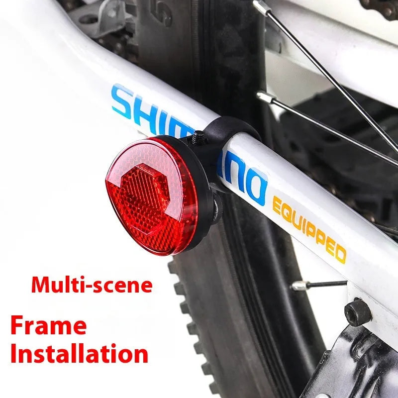 Red plastic anti-theft bicycle taillight bracket with integrated reflector mounted on a seat post.