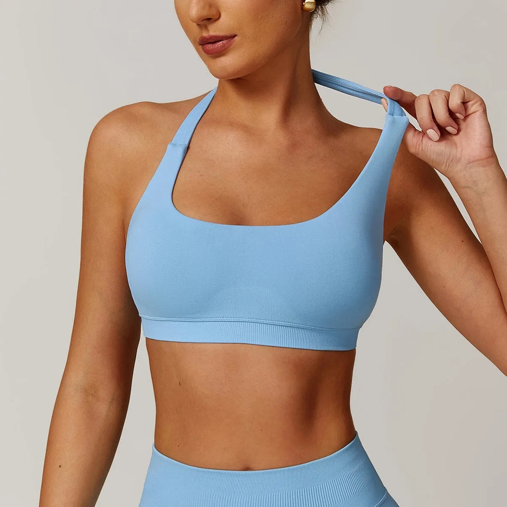 Close-up side view of a black halter neck sports bra for women, showing the strap detail and smooth nylon fabric.